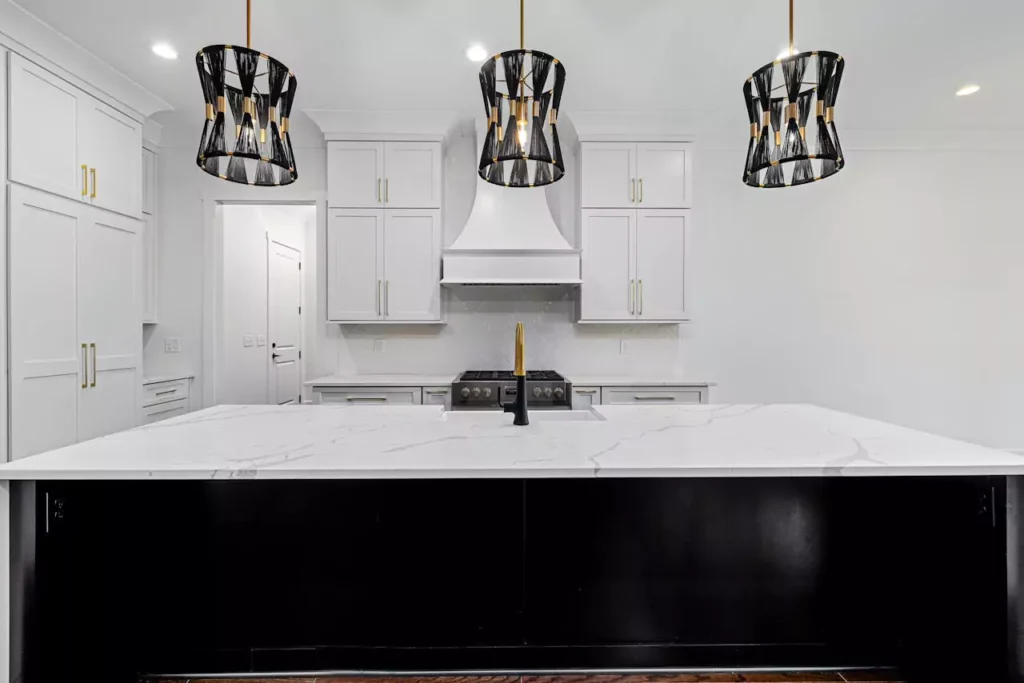 Black kitchen remodeling with white tiling and black pendant lighting