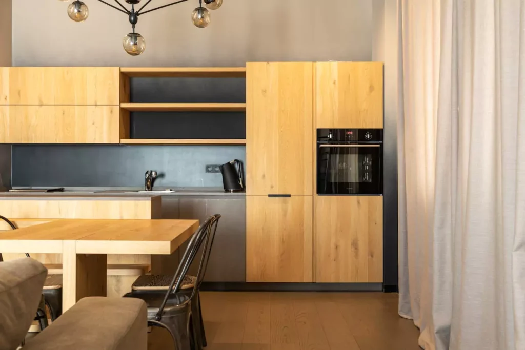 Warm kitchen remodel with graphite appliances and rich teak cabinetry